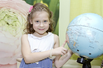 Little girl showing country on the globe