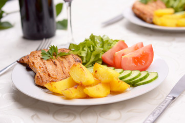 Dish with grilled pork loin, salad and potatoes