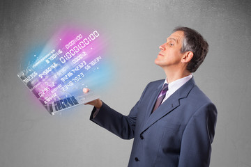 Businessman holding notebook with exploding data and numbers