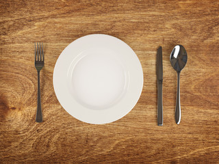 Plate and flatware on wooden table