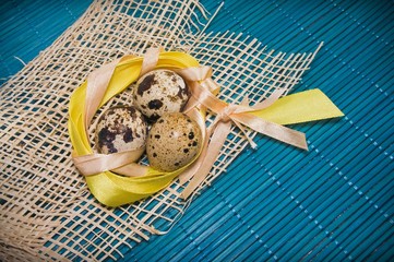 Easter background with quail eggs and ribbons