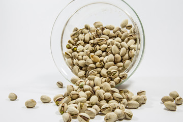 Viele Pistazien fallen aus einer Glasschale