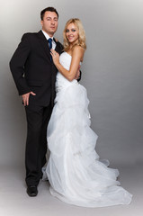 Happy married couple bride groom on gray background