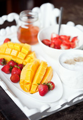 Healthy breakfast with mango, strawberry, honey and cereal