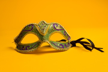 Green and gold Mardi Gras, venetian mask on Yellow background