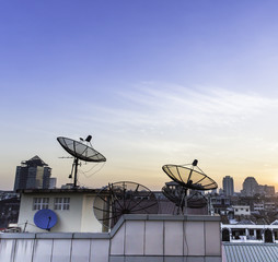 Satellite dish on the roof at sunset