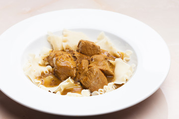pork pieces on cumin with pasta