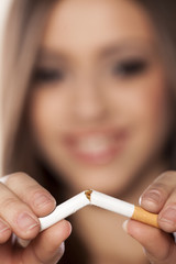 smiling girl breaks a cigarette with a focus on the foreground