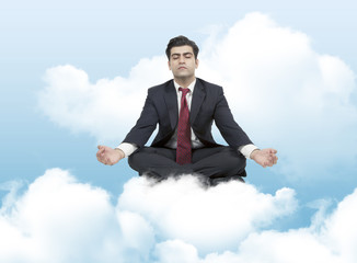 Business man meditates on clouds