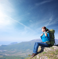 Woman with backpack on top of mountain