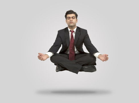 Business man meditates in mid air