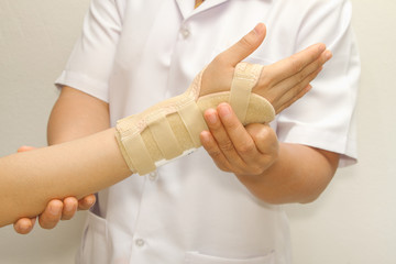 doctor putting wrist  brace on the patient's arm