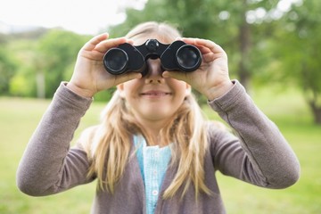 Girl looking through binoculars at park