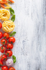 ingredients pasta tomatoes basil frame on white wooden backgroun