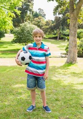 Obraz premium Full length portrait of a boy with ball at park