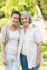 Fototapeta premium Portrait of smiling woman with adult daughter at park