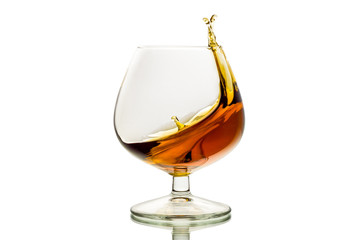 The glass with splashes brandy isolated