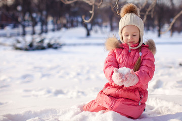 Adorable little girl outdoor in the park on cold winter day