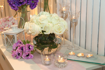 Table decorated with candles and white roses