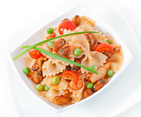 Farfalle pasta with seafood, cherry tomatoes and green peas