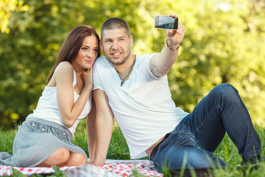 Beautiful young couple taking a self portrait in the meadow