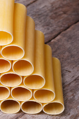 raw cannelloni on an old wooden board close-up. vertical
