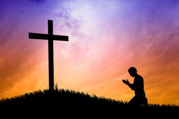 man praying under the cross