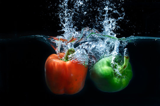 sweet pepper drop into water on black background.