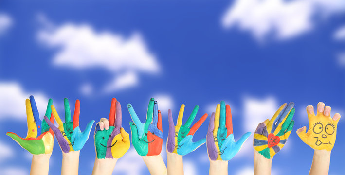 Painted hands with smile on sky background