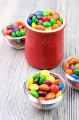 A jar and three bowls with multicolor candies