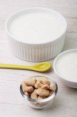 Cashew nuts and white milk product in bowls