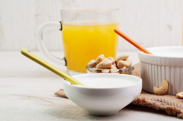 Two white bowls and a cup of orange juice