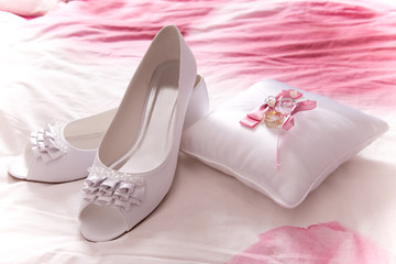 white shoes of bride with wedding rings