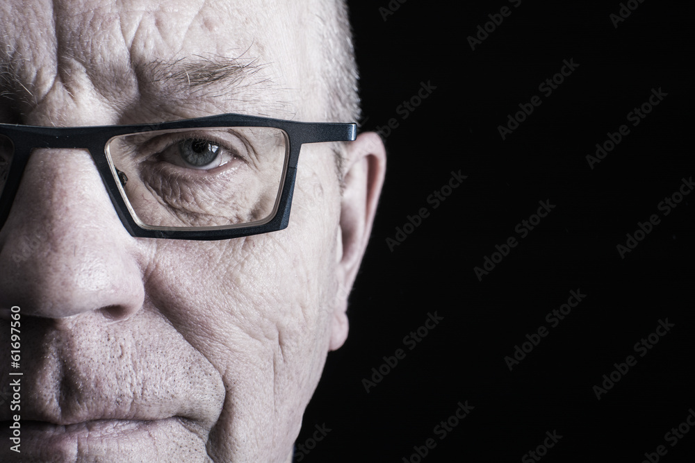 Wall mural closeup portrait of older man on black background.