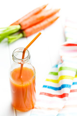 bottle of carrot juice with straw