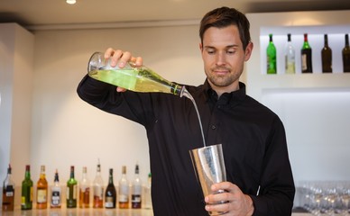 Happy bartender making a cocktail