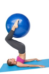 Side view of a fit woman exercising with fitness ball