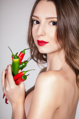 portrait of an attractive young woman holding up peppers