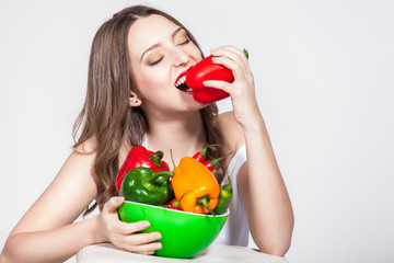 portrait of an attractive young woman holding up peppers