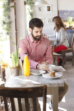 Modern young man sitting in coffee shop