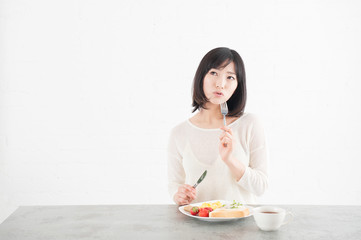 Obraz na płótnie Canvas 朝食をとる女性