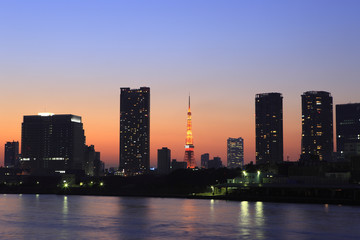 Fototapeta na wymiar Buildings along Sumida River and evening view of Tokyo Tower