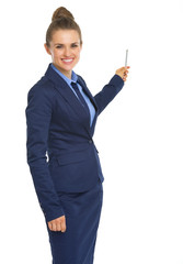 Smiling business woman pointing on copy space with pen