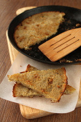 croutons fried in a pan on a dark wooden background