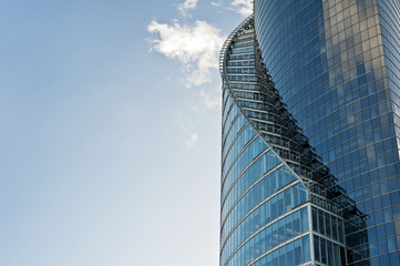 Curves of modern glass building on a blue sky background