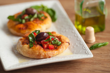 Mini pizza on a plate on the table.