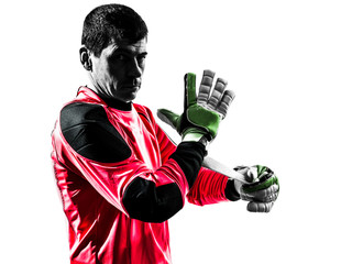 caucasian soccer player goalkeeper man adjusting gloves silhouet