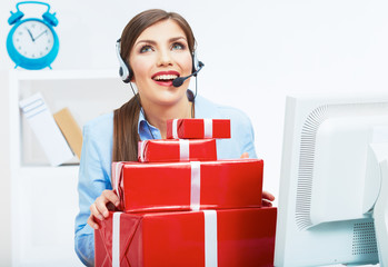 Smiling operator seat at table with red gift box. Happy busines