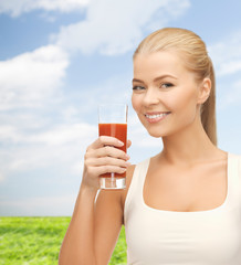 smiling woman holding glass of tomato juice