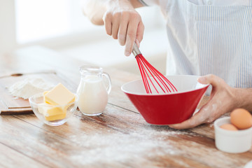 close up of male hand whisking something in a bowl